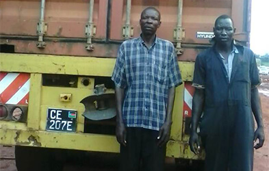 John Muteba and his colleague stand outside their vehicle
